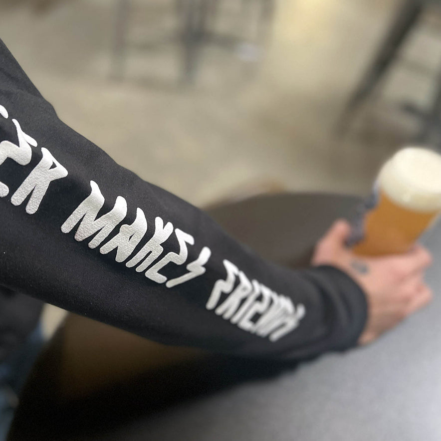Stay Weird Stay Dead print on a black hoodie sleeve