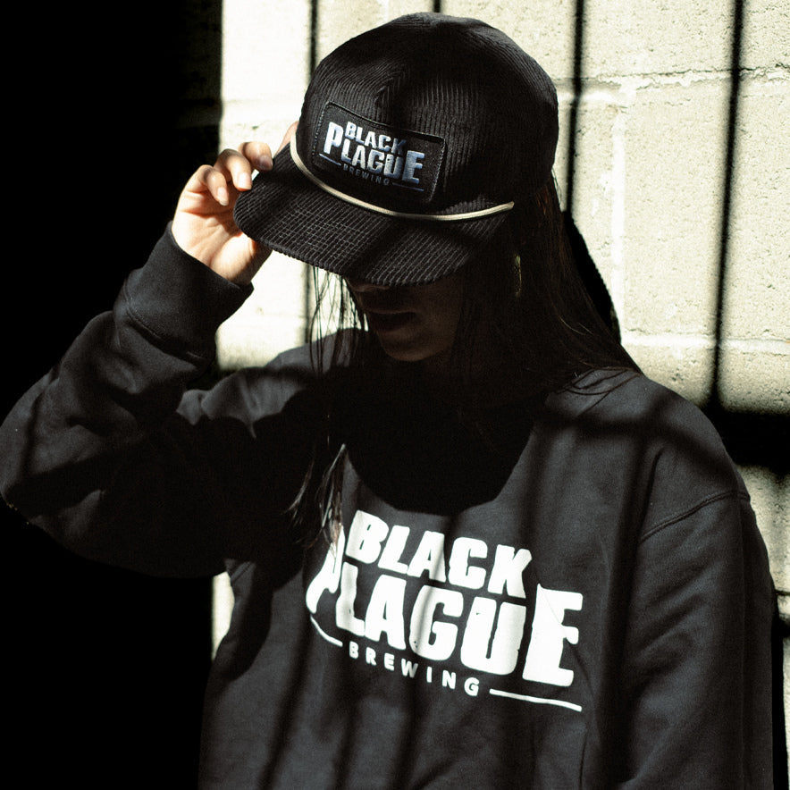Black Plague cap and sweatshirt worn outside