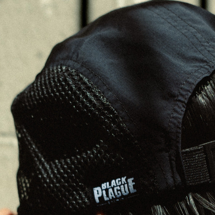 Black mesh camp hat with a woven BLACK PLAGUE label